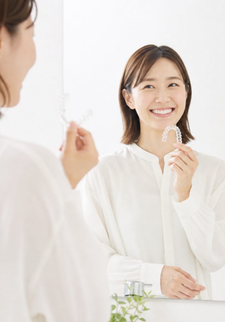 マウスピースを手にした笑顔の女性